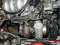 From the top.  With that emissions crap out of the way there's enough room to install the turbo mounted to the manifold.